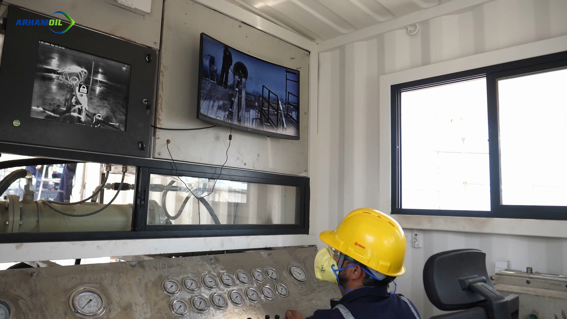 An operator in a hard hat watches live video of the work at the control panel.